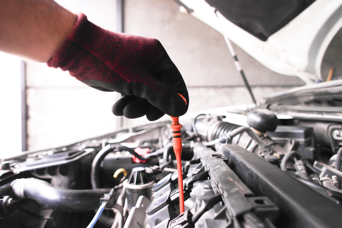 Commercial vehicle fleet maintenance technician checking engine oil, coolant and other essential vehicle fluids